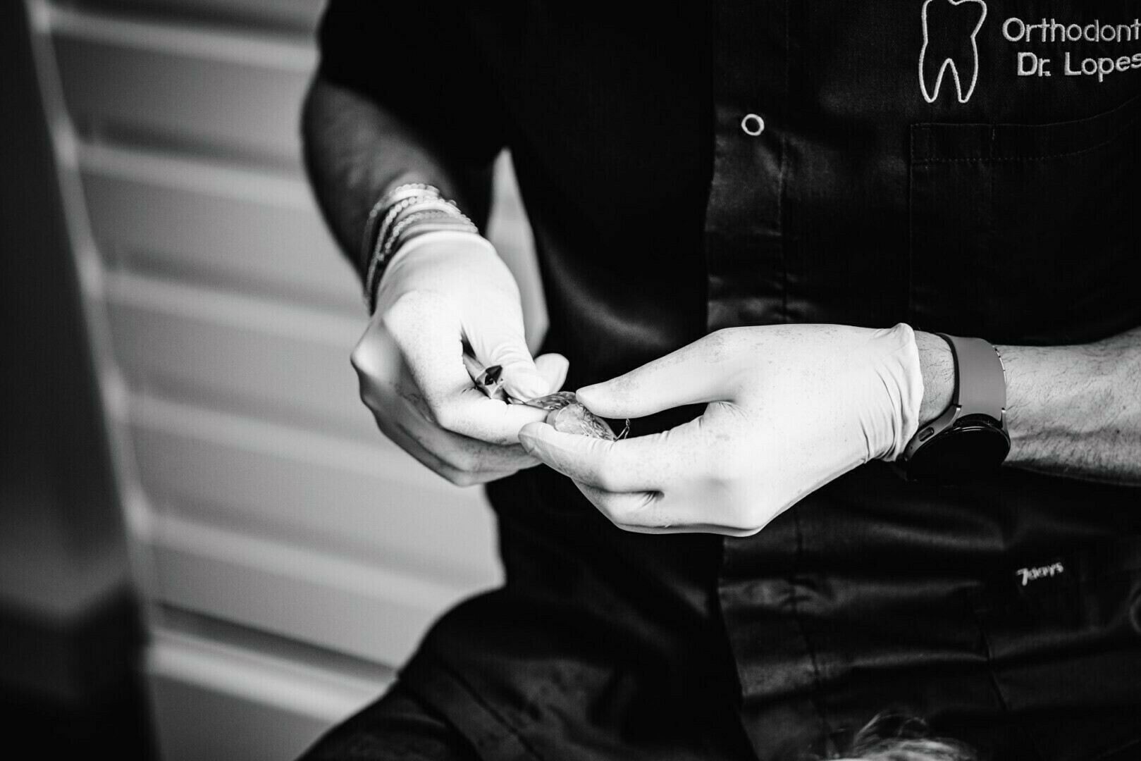 Aligneur transparent tenu par le Docteur Lopes, gants
